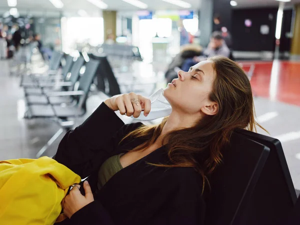 Femme avec les yeux fermés assis à l'aéroport attendant les bagages de vol — Photo