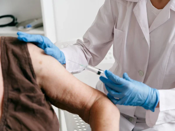 En sjuksköterska injicerar en injektion i armvaccinets pass närbild — Stockfoto