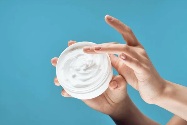 Mão feminina frasco branco com creme dermatologia cuidados da pele — Fotografia de Stock