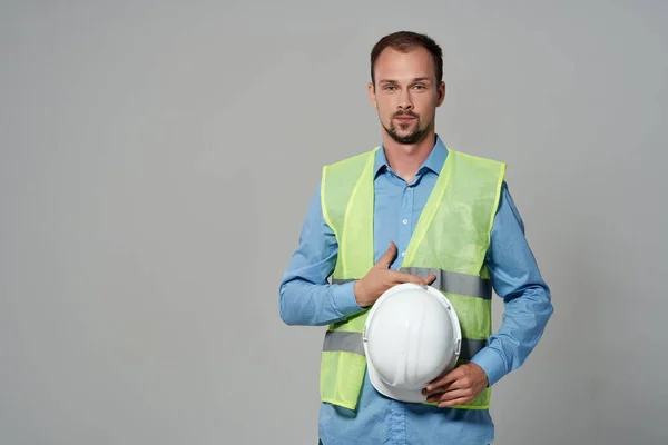 Man in white helmet blueprints builder light background — Stock Photo, Image