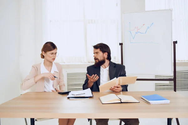 Hombre y mujer sentados en un escritorio oficina trabajo comunicación profesionales — Foto de Stock