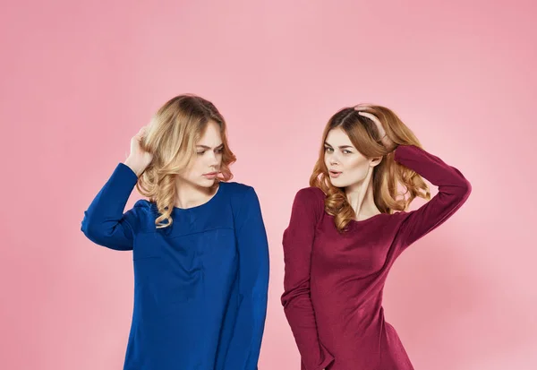 Novias alegres en vestidos de la amistad están de pie lado a lado en un modelo de fondo rosa —  Fotos de Stock