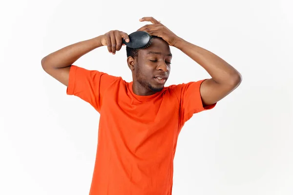 Afro-americano com olhos fechados penteando cabelo laranja t-shirt vista cortada — Fotografia de Stock