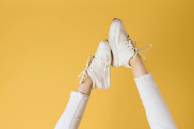 Modern moda pozu veren kadın ayaklı beyaz spor ayakkabılar.