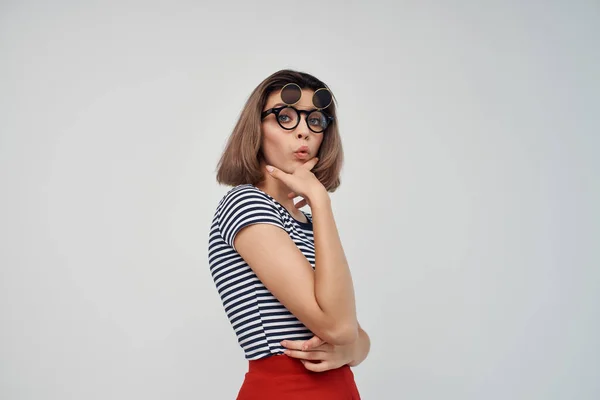 Donna che indossa occhiali di moda a righe t-shirt luce sfondo glamour — Foto Stock
