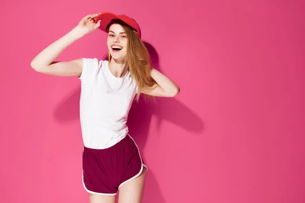 Vidám nő fehér póló és rövidnadrág pózol nyári rózsaszín háttér — Stock Fotó