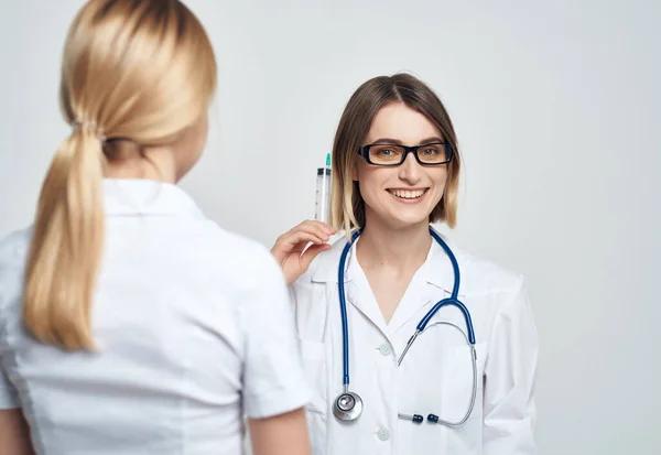 Siringa medico femminile in mano trattamento sfondo chiaro — Foto Stock