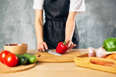 Siyah önlüklü kadın sağlıklı yemek pişiriyor salata diyeti yiyor.