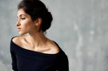 Siyah elbiseli esmer. Makyaj dekorasyonu zarif bir tarz.