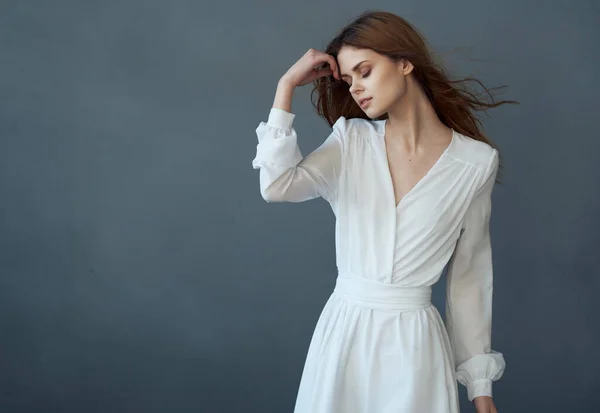 Жінка в білій сукні красива зачіска мода розкоші позує темний фон — стокове фото