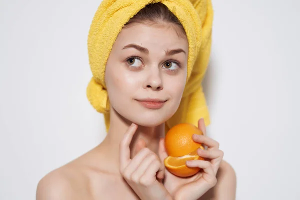 Mulher com toalha amarela na cabeça ombros nus fruta laranja vitamina — Fotografia de Stock