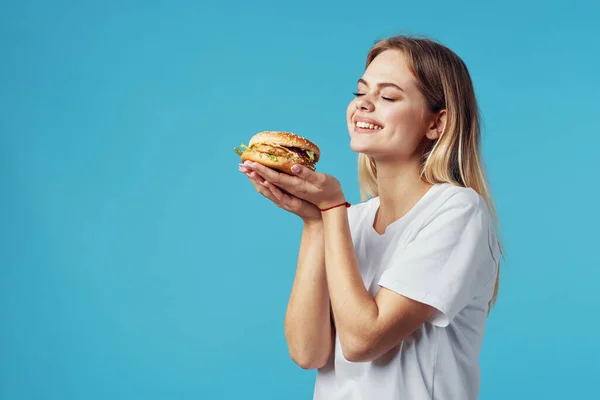 Блондинка в белой футболке гамбургер фаст-фуд закуски радость — стоковое фото