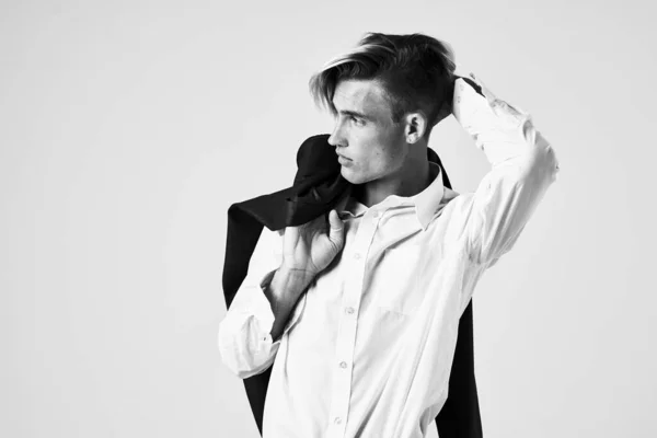 Stilig man i en vit skjorta med en jacka på sina axlar fashionabla frisyr studio — Stockfoto