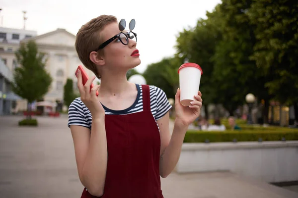 Женщина с чашкой напитка в очках на открытом воздухе ходить свежий воздух — стоковое фото