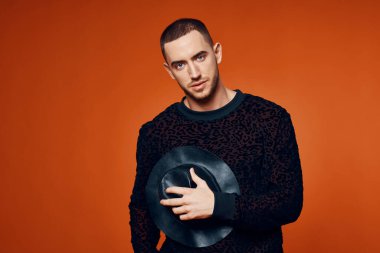 Moda stüdyosu tarzında siyah kazaklı bir adam.