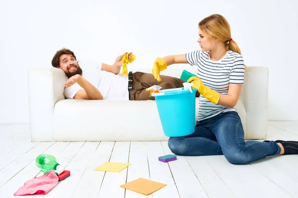 Man and woman near the sofa cleaning of the apartment protective gloves — Stock Photo, Image