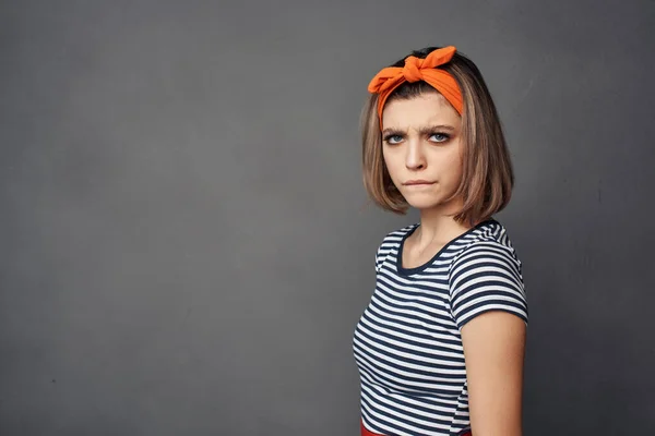 woman in striped t-shirt with orange headband posing