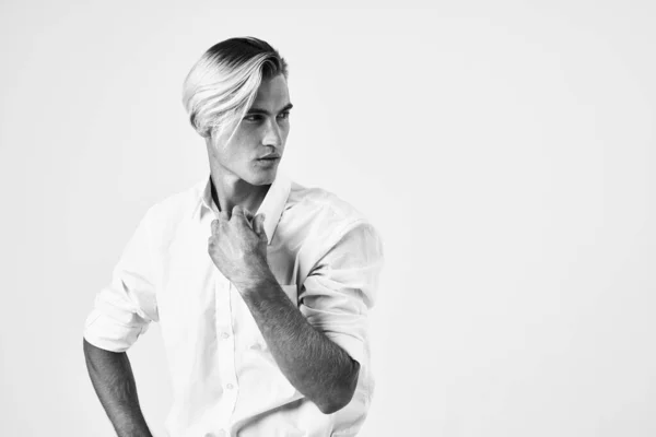 Jóképű férfi fehér ingben divat frizura önbizalom életmód fény háttér — Stock Fotó