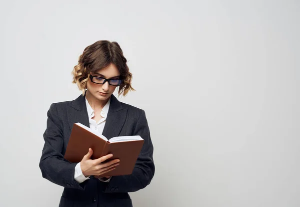 Donna in giacca e cravatta con un libro in mano sfondo isolato — Foto Stock