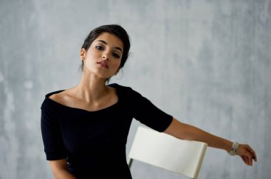 Siyah elbiseli kadın cazibe dekorasyon stüdyosunda poz veriyor.