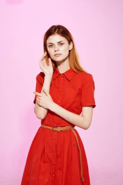 Kırmızı elbiseli, kızıl saçlı bir kadın el kol hareketi yaparak lüks ve izole bir hayat sürüyor.