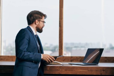 Pencere kenarındaki girişimci elinde tablet teknolojisiyle