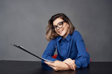 İş kadını ellerindeki çalışma masası klasöründe oturuyor. Boşluğu kopyala