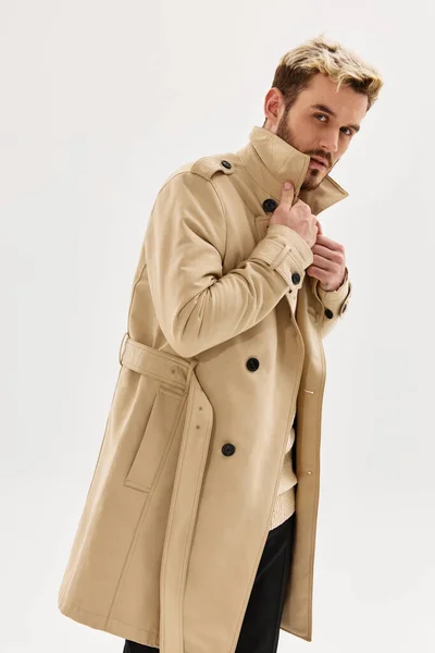Knappe man in beige jas herfst stijl mode studio — Stockfoto