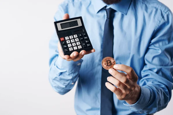 Homem segurando uma calculadora criptomoeda bitcoin investimento em dinheiro virtual — Fotografia de Stock