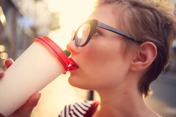 Nő egy csésze ital szabadban piros ajkak divat séta — Stock Fotó