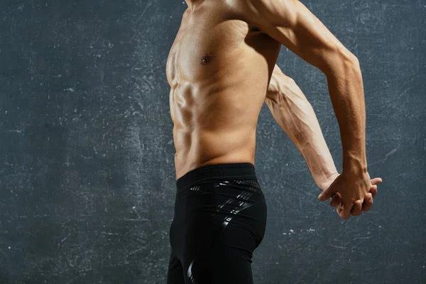 Σπορ άνθρωπος με ένα φουσκωμένο σώμα ασκήσεις προπόνηση σκούρο φόντο — Φωτογραφία Αρχείου