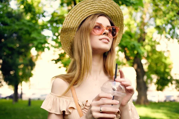 Bonita mujer en un sombrero en el parque beber descanso verano — Foto de Stock