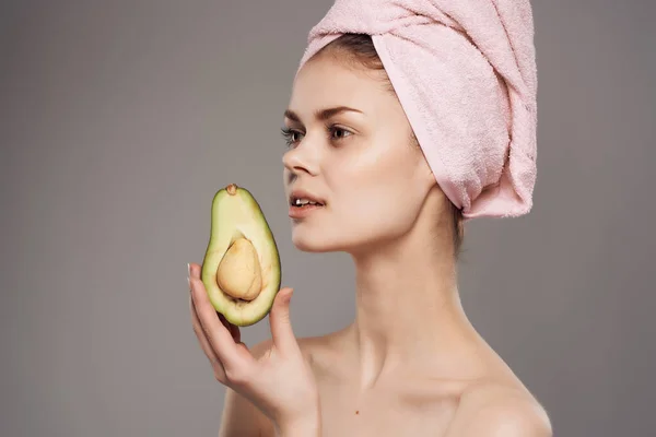 Mulher com uma toalha na cabeça com abacate de frutas posando close-up — Fotografia de Stock