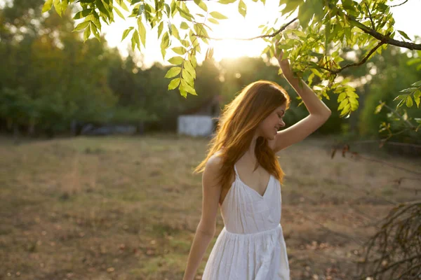 Glad kvinna i en vit klänning på sommaren utomhus i fält — Stockfoto