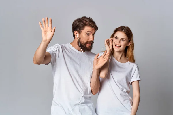 Молода пара в білих футболках слухає музику — стокове фото