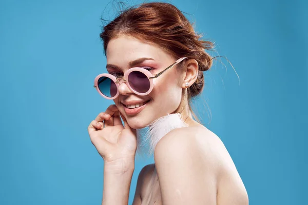Žena s holými rameny sluneční brýle módní modré pozadí — Stock fotografie