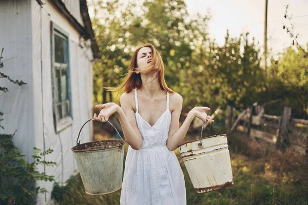 Frau in weißem Kleid arbeitet in der dörflichen Natur — Stockfoto