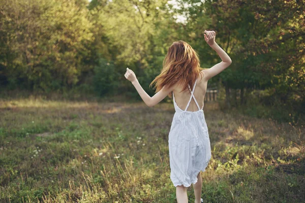 Beyaz elbiseli kadın doğa yürüyüşü yapıyor. — Stok fotoğraf