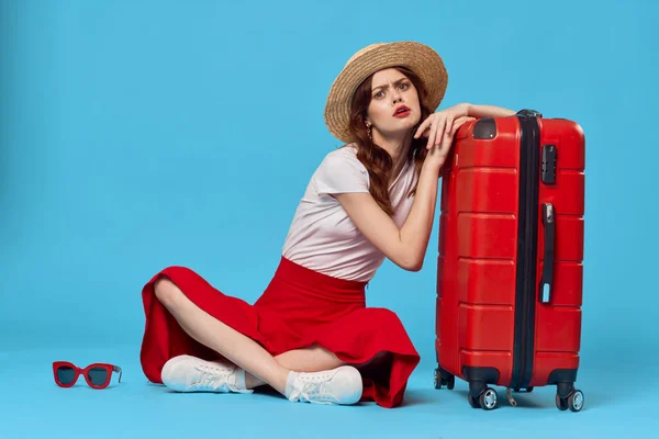 明るい女性の帽子の上に座って赤いスーツケースの乗客隔離された背景 — ストック写真