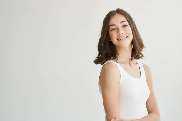 Vacker kvinna i en vit t-shirt hårvård isolerad bakgrund — Stockfoto