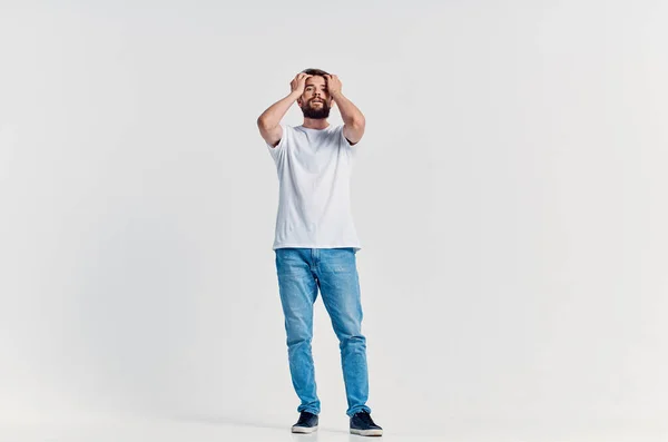 Homem em branco t-shirt emoções posando luz de fundo — Fotografia de Stock