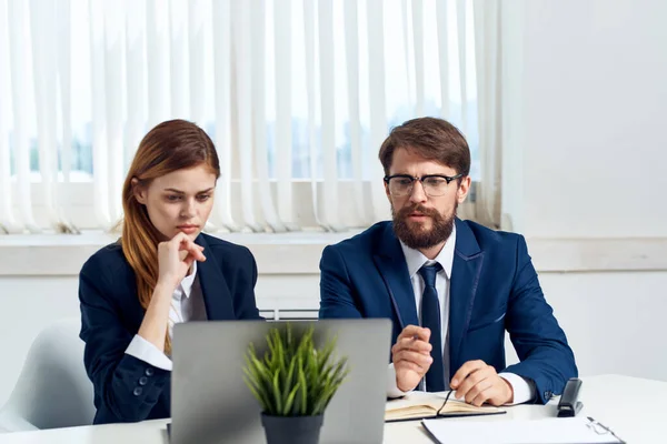 Hombre y mujer de negocios charlando en la oficina delante de un ordenador portátil profesionales — Foto de Stock