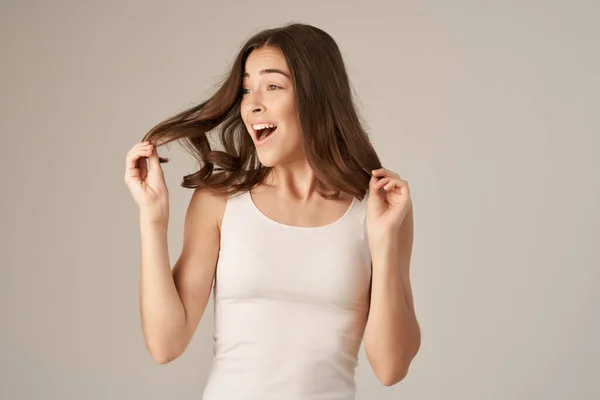 Bela mulher em um branco t-shirt cabelo cuidado isolado fundo — Fotografia de Stock