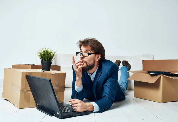 Un homme bon marché se trouve sur le sol devant un bureau d'ordinateur portable changer de lieu de travail — Photo