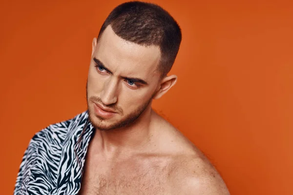 Homem bonito na camisa nu torso posando moda laranja fundo — Fotografia de Stock