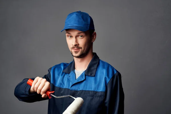 Un hombre en un uniforme de trabajo un pintor renovación de una obra de decoración de apartamentos — Foto de Stock