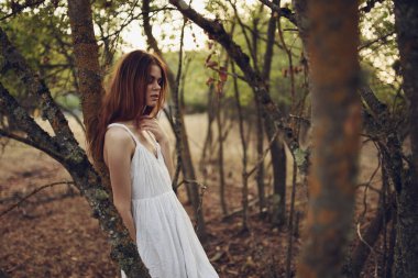 Beyaz yaz elbiseli kadın ağaçlar doğa yolculuğu