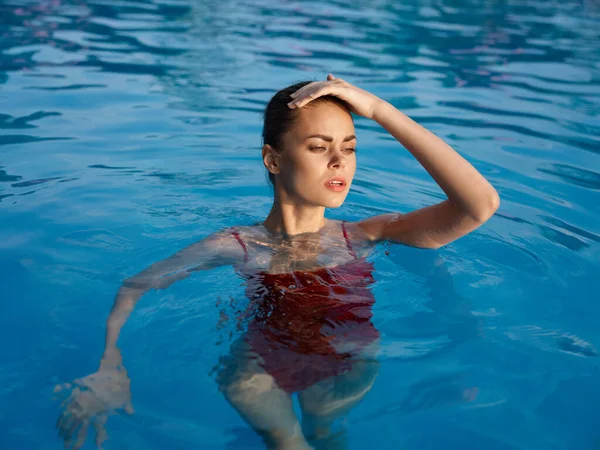 Mujer en traje de baño rojo en la piscina Cosméticos de vacaciones de lujo —  Fotos de Stock