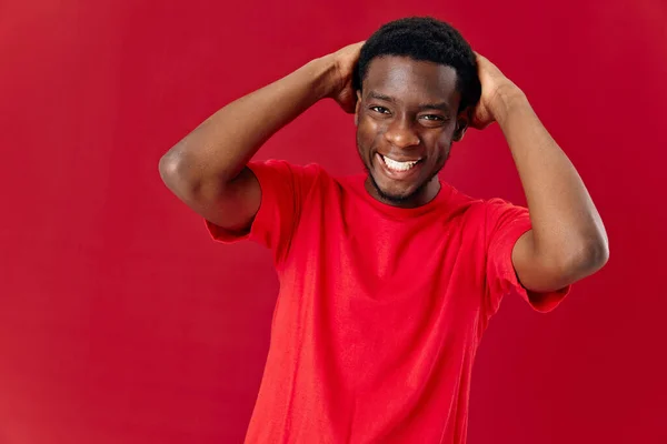 Homem alegre de aparência africana segurando sua cabeça isolada fundo — Fotografia de Stock