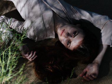 Ceketli çekici kadın yerde yatıyor. 